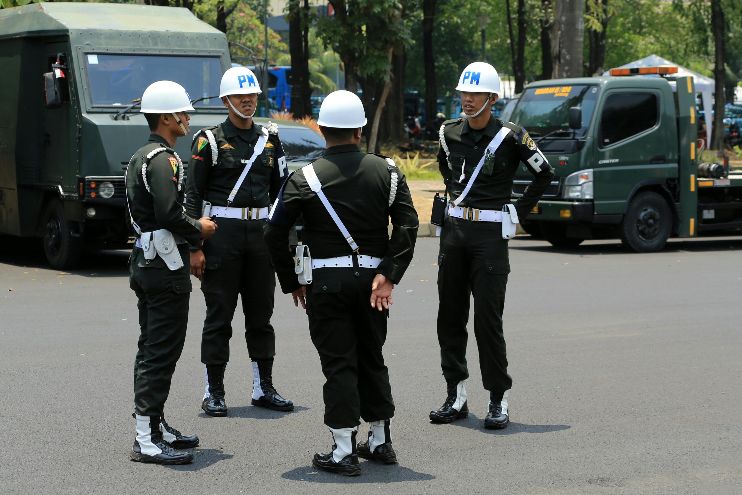 Group of military policemen in uniform standing on a city street.